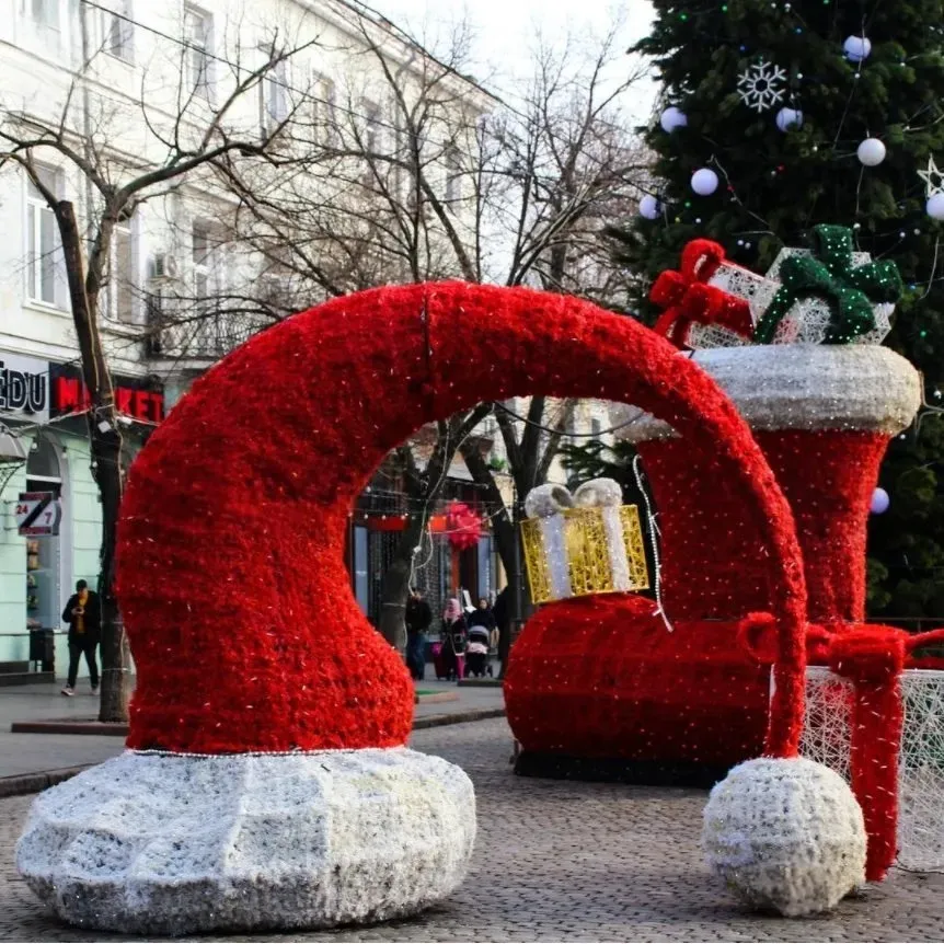 Christmas Boot and Santa Hat Light Decoration – Lights Off giant christmas boot and santa hat motif lights turned off outdoor holiday decoration display in city square