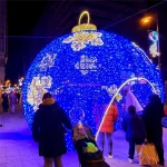 giant christmas ball light decoration walk through outdoor motif lighting project with visitors experiencing the installation