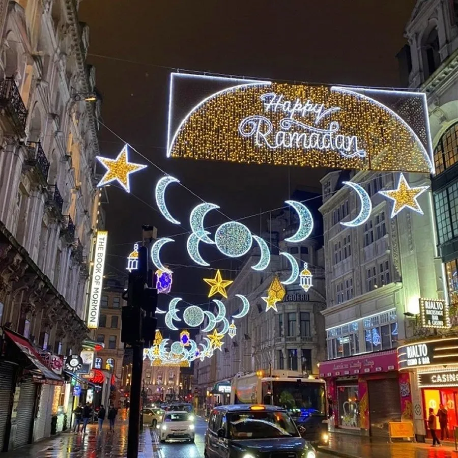 Ramadan street light decoration with LED crescent moon and star motif across city street